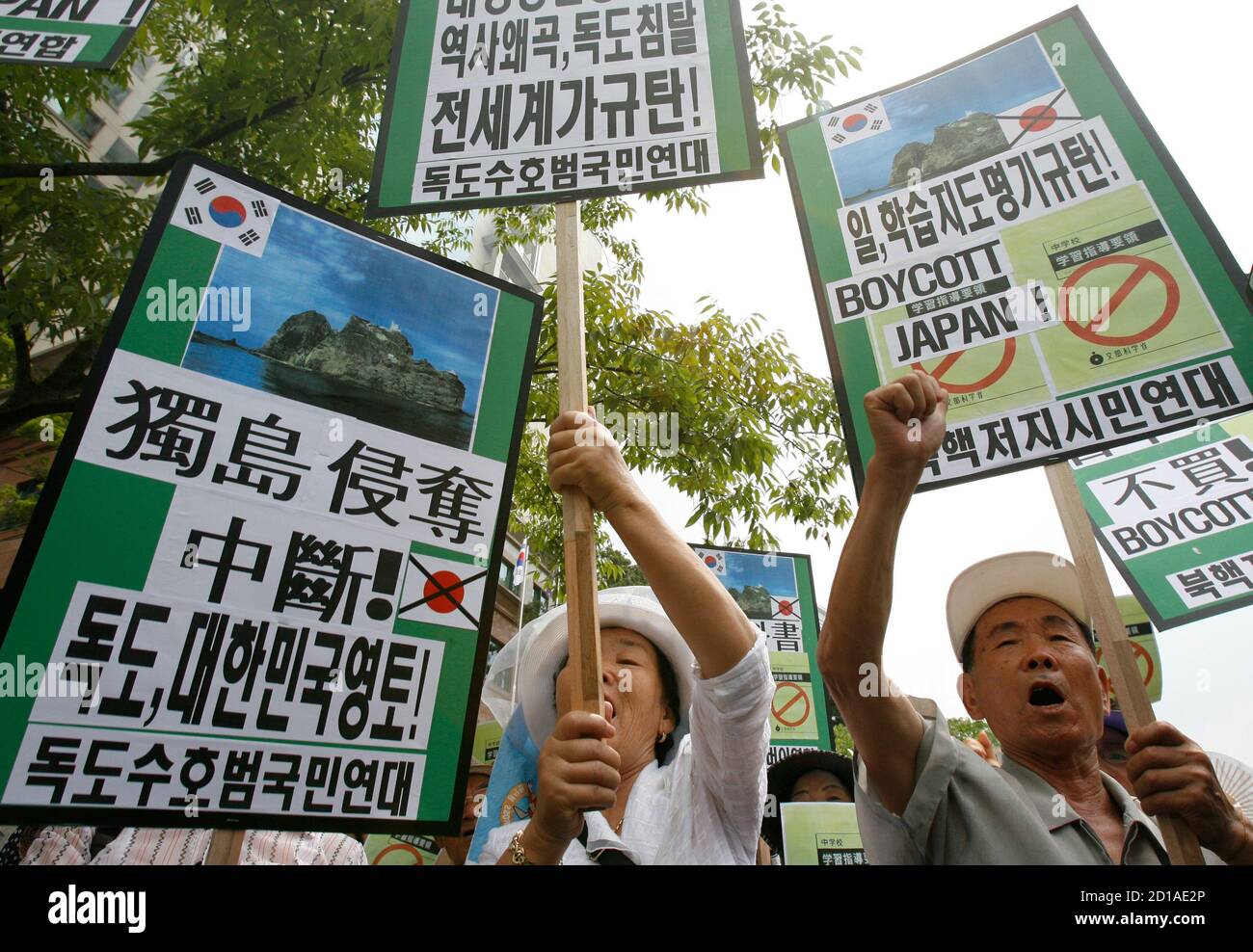 Protesters chant slogans at a demonstration against Japan's sovereignty claim over a group of desolate volcanic islets Seoul and Pyongyang call Dokdo and Tokyo calls Takeshima, in front of Japanese embassy in Seoul July 15, 2008. South Korea's coastguard said on Tuesday it had stepped up patrols near the islands, a day after Seoul recalled its ambassador in anger at new Japanese claims to the rocky outcrops. On Monday, Tokyo said it had told Seoul that it would refer in a middle school teaching guide to the islands as Japanese territory. A sign (L) reads "Stop robbing Dokdo. Dokdo, South Korea Foto de stock