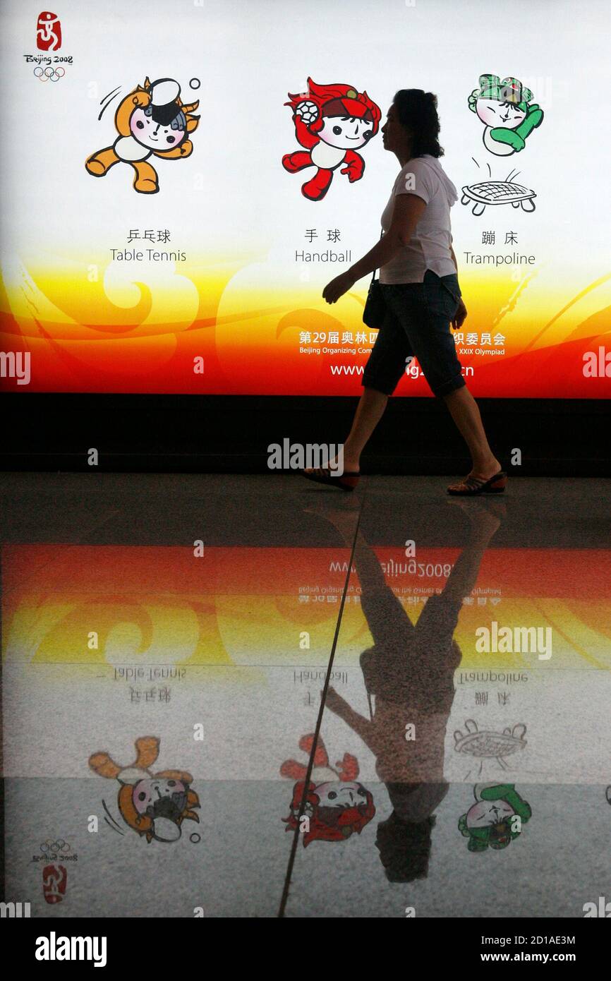 Un viajero pasa por un anuncio de mascotas olímpicas de Beijing en el  Aeropuerto Internacional de Beijing Capital 17 de julio de 2008. China ha  transformado su capital para los Juegos Olímpicos