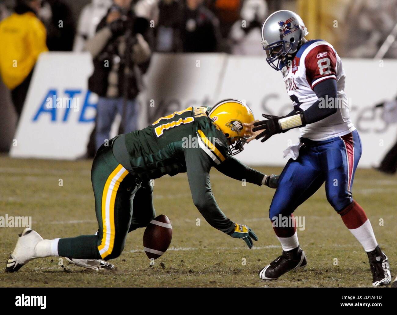 Montreal Alouettes' quarterback Marcus Brady (R) is stripped of the ball by  Edmonton Eskimos' Fred Perry during the second half of their CFL football  game in Edmonton October 31, 2008. REUTERS/Dan Riedlhuber (