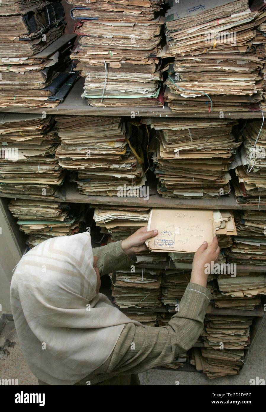 A librarian pulls out a folder of historical documents in Iraq's National  library in Baghdad August 12, 2007. Saad Eskander, Director of the National  Library and Archive said on Saturday he feared
