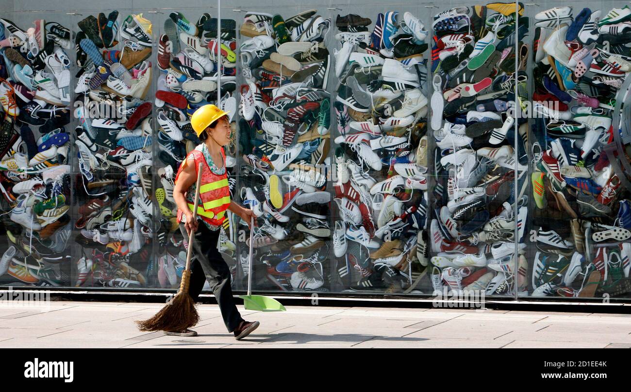 Un trabajador pasa por la nueva tienda Adidas Brand Center, la más grande  del mundo de su clase, en Beijing el 3 de julio de 2008. Adidas abrirá su  tienda Adidas más