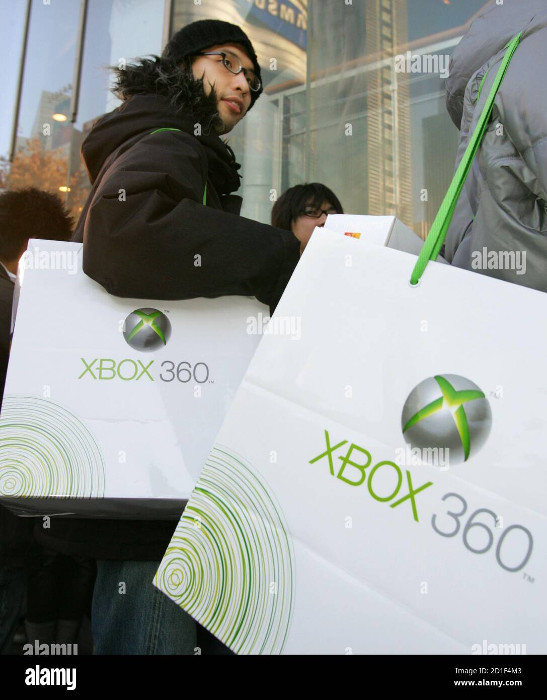 Japanese customers carry their newly purchased Microsoft Corp's Xbox 360  video game console after an early morning launch in Tokyo December 10, 2005.  Xbox 360 is the first next-generation game machine to