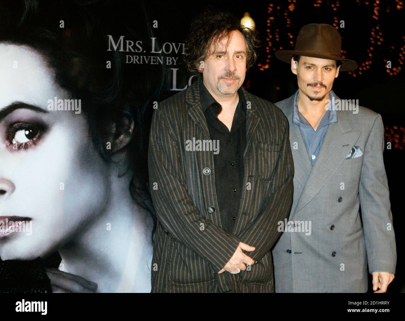 El director Tim Burton (L) y el actor Johnny Depp posan junto a un cartel  de la co-estrella Helena Bonham Carter en una proyección especial de la  película DreamWorks Pictures 'Weeney Todd: