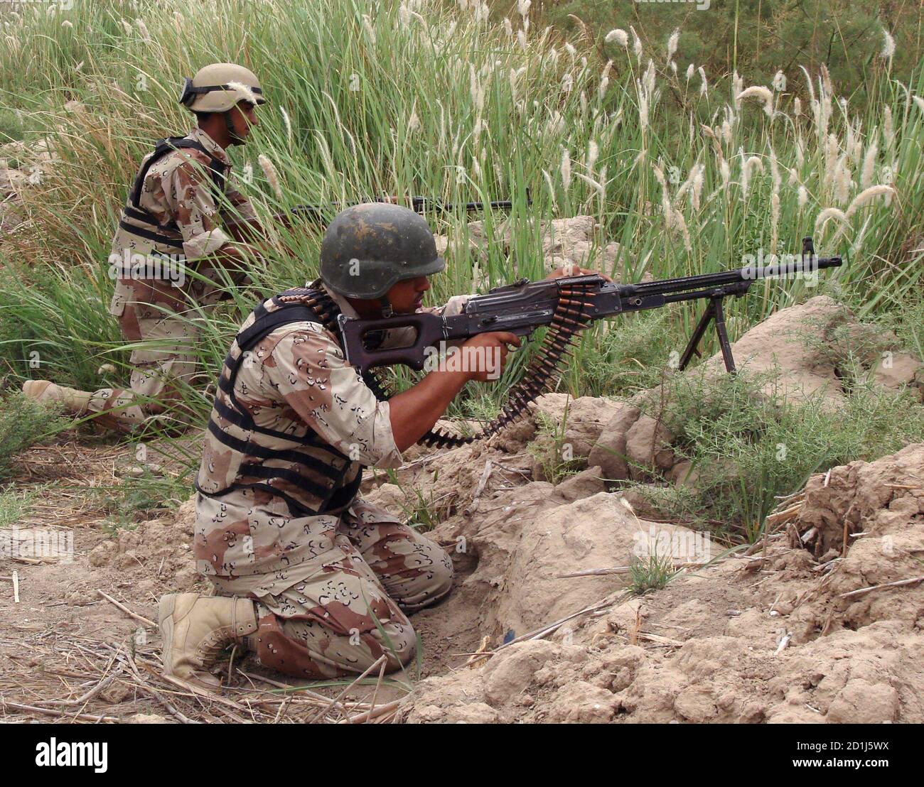 Soldados iraquíes toman posición en las afueras de Mahmoudiya, 30km (20 millas) al sur de Bagdad, 16 de mayo de 2007 mientras continúan la búsqueda de tres soldados estadounidenses desaparecidos. Las fuerzas estadounidenses que buscaban a los tres soldados dijeron el martes que los militantes sospechosos de al Qaeda que sostenían a los hombres estaban atrapados en un área de tierras agrícolas cerca de Bagdad. Los soldados, parte de una unidad más grande enviada para interceptar bombas en la carretera en una fortaleza militante árabe sunita, desaparecieron después de una emboscada coordinada el sábado en la que otros cuatro soldados estadounidenses y un traductor del ejército iraquí fueron asesinados. REUTERS/Ibrahim Sultan (IRAK) Foto de stock