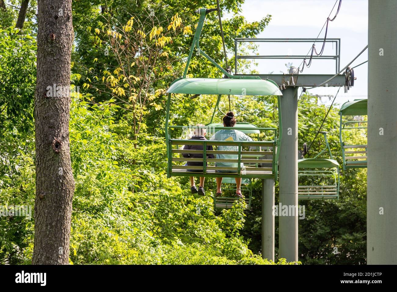 Una mujer joven y un niño viajan a través de la copa de los árboles en el Sky Safari por encima del Fort Wayne Children's Zoo. Foto de stock