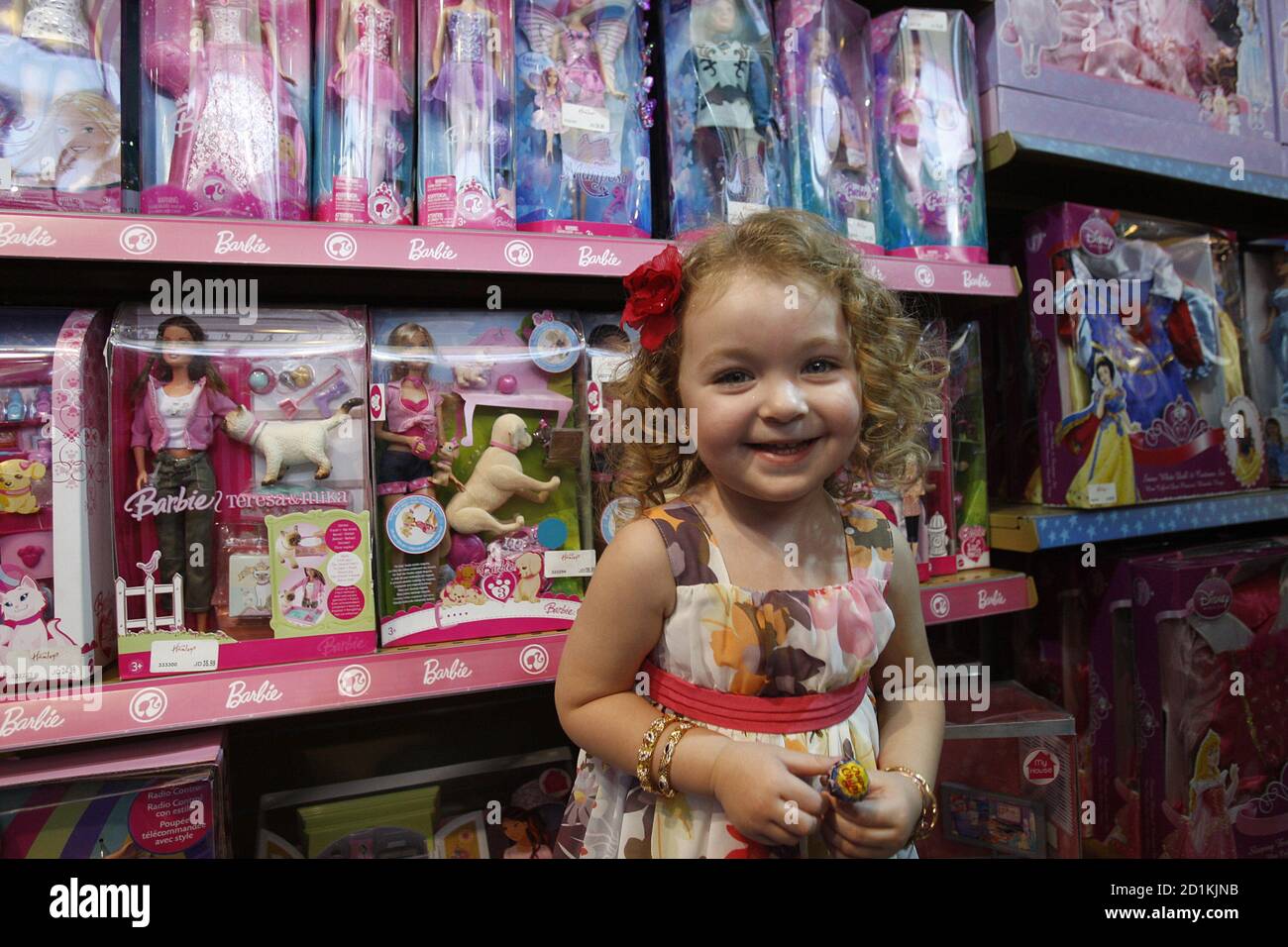 Una niña jordana posa cerca de muñecas Barbie en una tienda de juguetes  durante la fiesta de 50 cumpleaños de Barbie en Amman 7 de agosto de 2009.  REUTERS/Ali Jarekji (SOCIEDAD DE