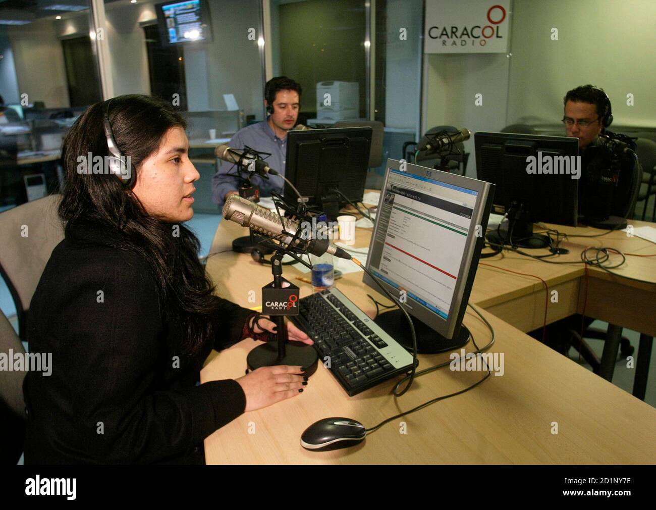 Los miembros del equipo que produce el programa de radio 'Gacapping Voices'  hablan en el aire con un pariente de una persona secuestrada en la estación  de radio Caracol en Bogotá el
