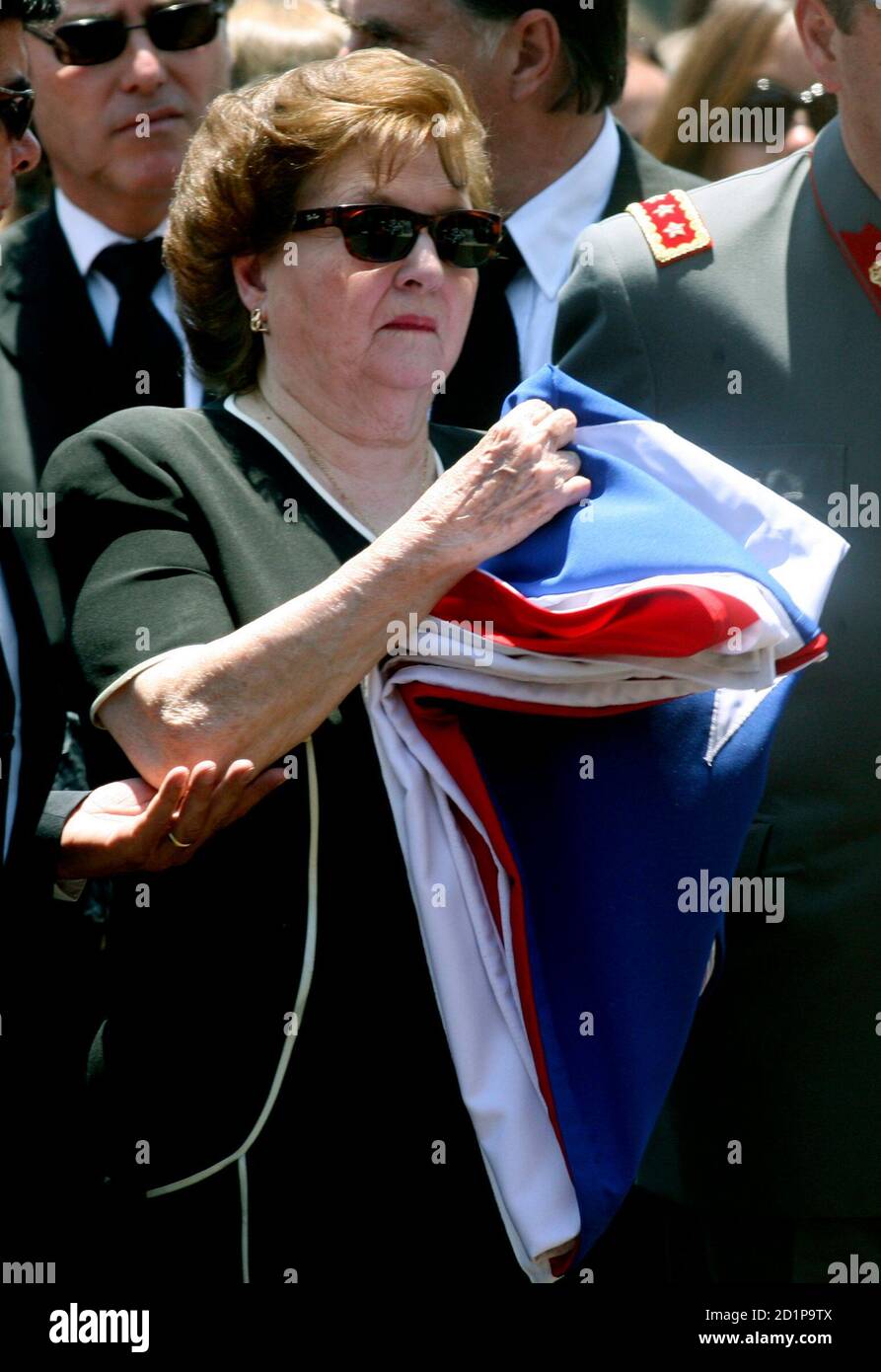 lucia-hiriart-widow-of-former-chilean-dictator-augusto-pinochet-holds-the-flag-that-draped-her-husbands-coffin-at-the-end-of-his-funeral-mass-in-the-courtyard-of-the-military-college-in-santiago-december-12-2006-reuters-victor-ruiz-caballero-chile-2d1p9tx.jpg