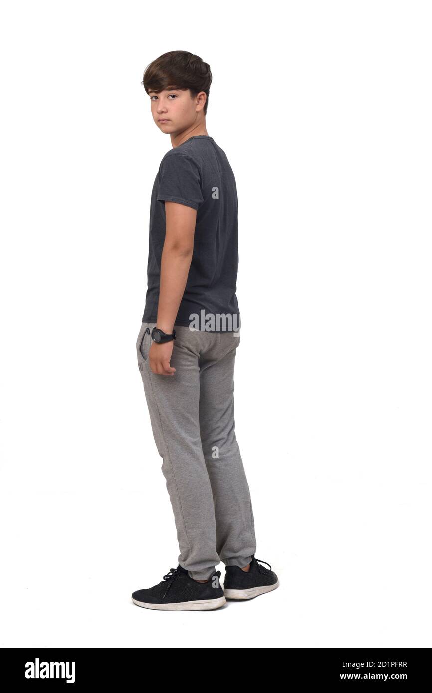 adolescente chico llevando ropa deportiva de pie sobre fondo blanco, vista trasera y.. mirando la cámara Fotografía de stock Alamy
