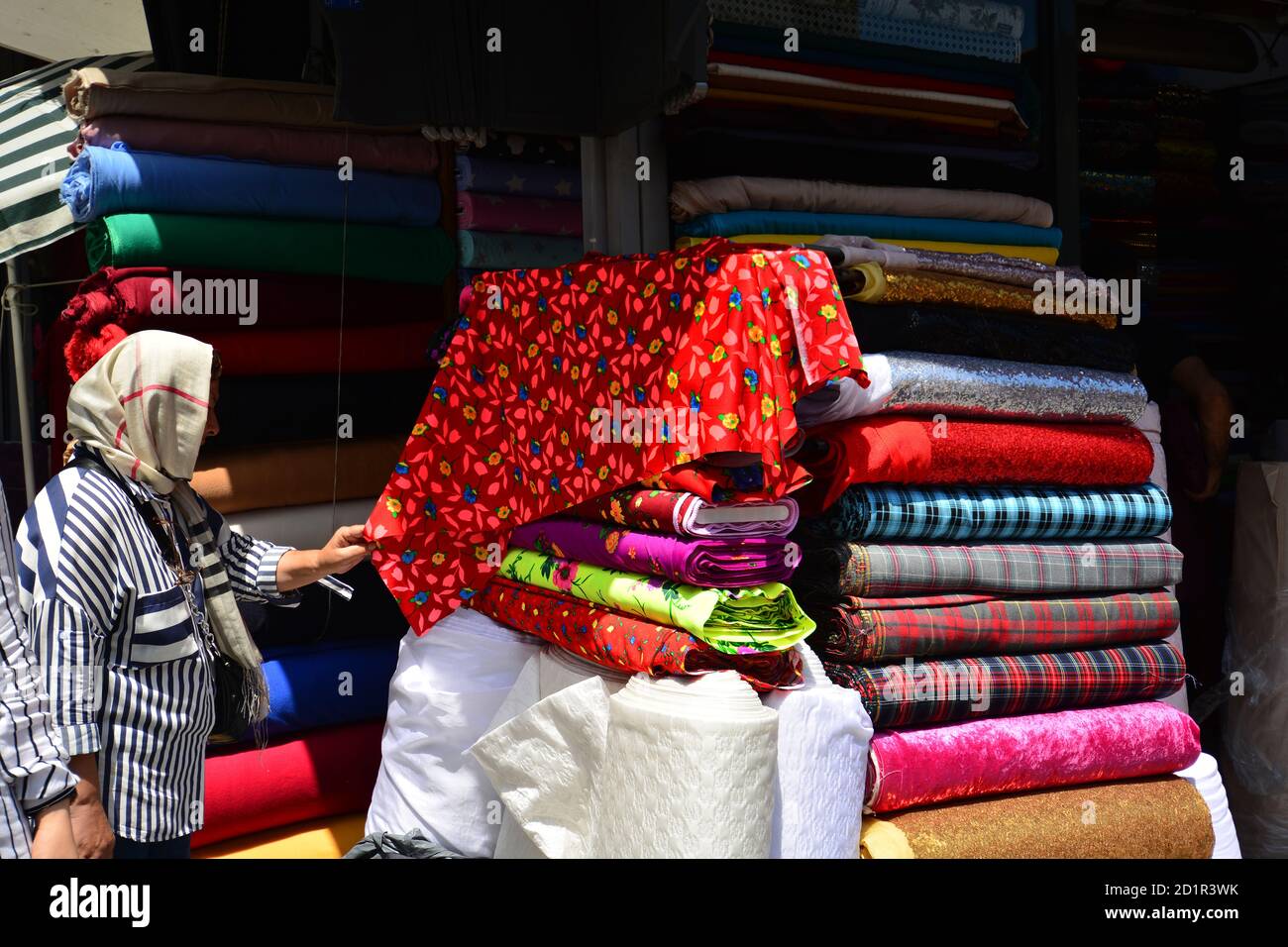 Una mujer turca que compra tela en una tienda. Estambul, Turquía Foto de stock
