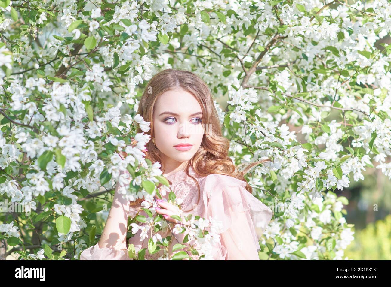 joven hermosa niña cerca del árbol en primavera Foto de stock