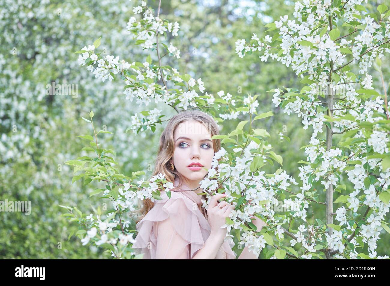 joven hermosa niña cerca del árbol en primavera Foto de stock