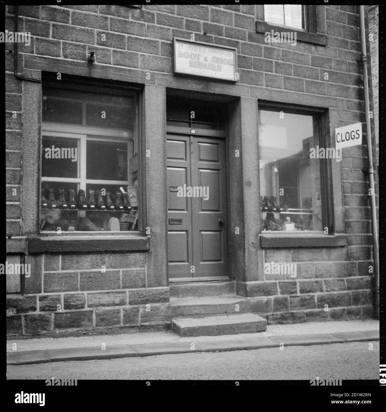 Los zuecos se muestran en la ventana de H Greenwood "reparaciones de botas y zapatos" tienda, establecida en 1925. Foto de stock