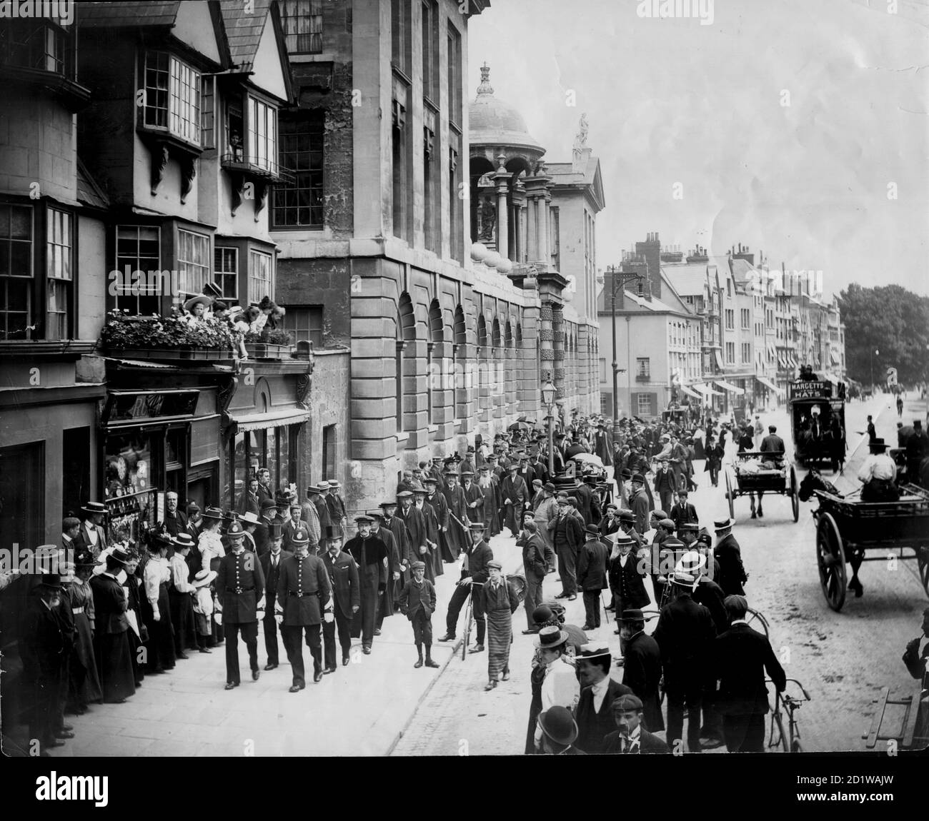 High Street, Oxford, Oxfordshire. Una vista de la calle alta con el Queen's College a la izquierda, mostrando la procesión de la Universidad de Encaenia en su camino al Teatro Sheldonian para una ceremonia. Foto de stock