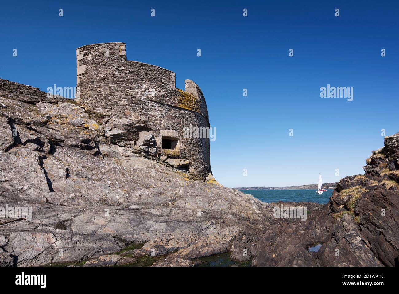 Castillo de Pendennis, Castle Drive, Pendennis Point, Falmouth, Cornwall. Vista general de la pequeña casa de Dennis Blockhouse del castillo desde el sureste, con un yate en Falmouth Bay en el fondo. Foto de stock