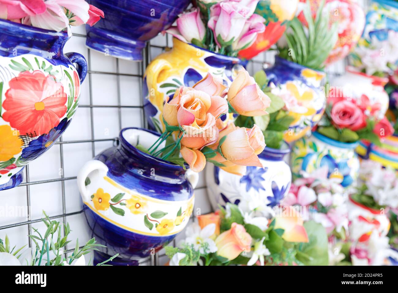 Jarrones coloridos de cerámica con flores en una pared de una tienda en un  pueblo tradicional blanco, Mijas, España Fotografía de stock - Alamy