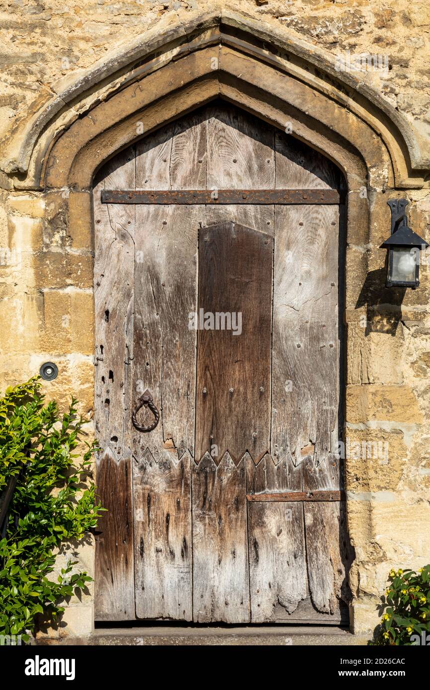 Una vieja puerta de madera medieval en la entrada de una casa de campo tradicional de Cotswold, Burford, Gloucestershire, Inglaterra, Reino Unido Foto de stock