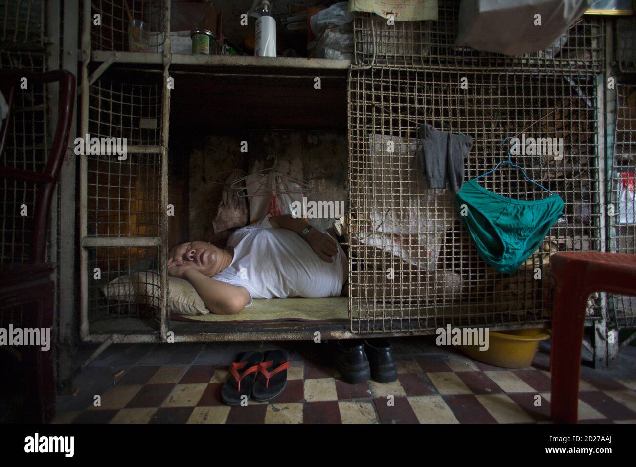 Yan Chi-keung duerme en una pequeña jaula en el distrito Tai Kok Tsui de Hong  Kong el 16 de julio de 2008. En distritos más antiguos como Tai Kok Tsui,  cientos de