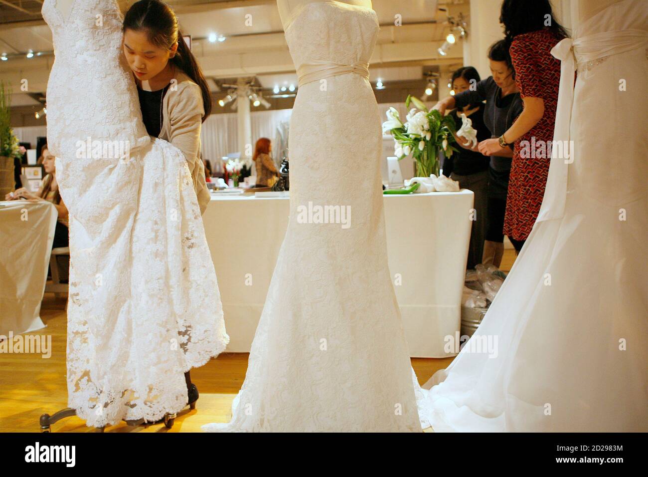 Katherine Yung, la vendedora de vestidos de boda, prepara vestidos para la presentación del stand de antes de espectáculo de bodas en Nueva York el 2 de abril de