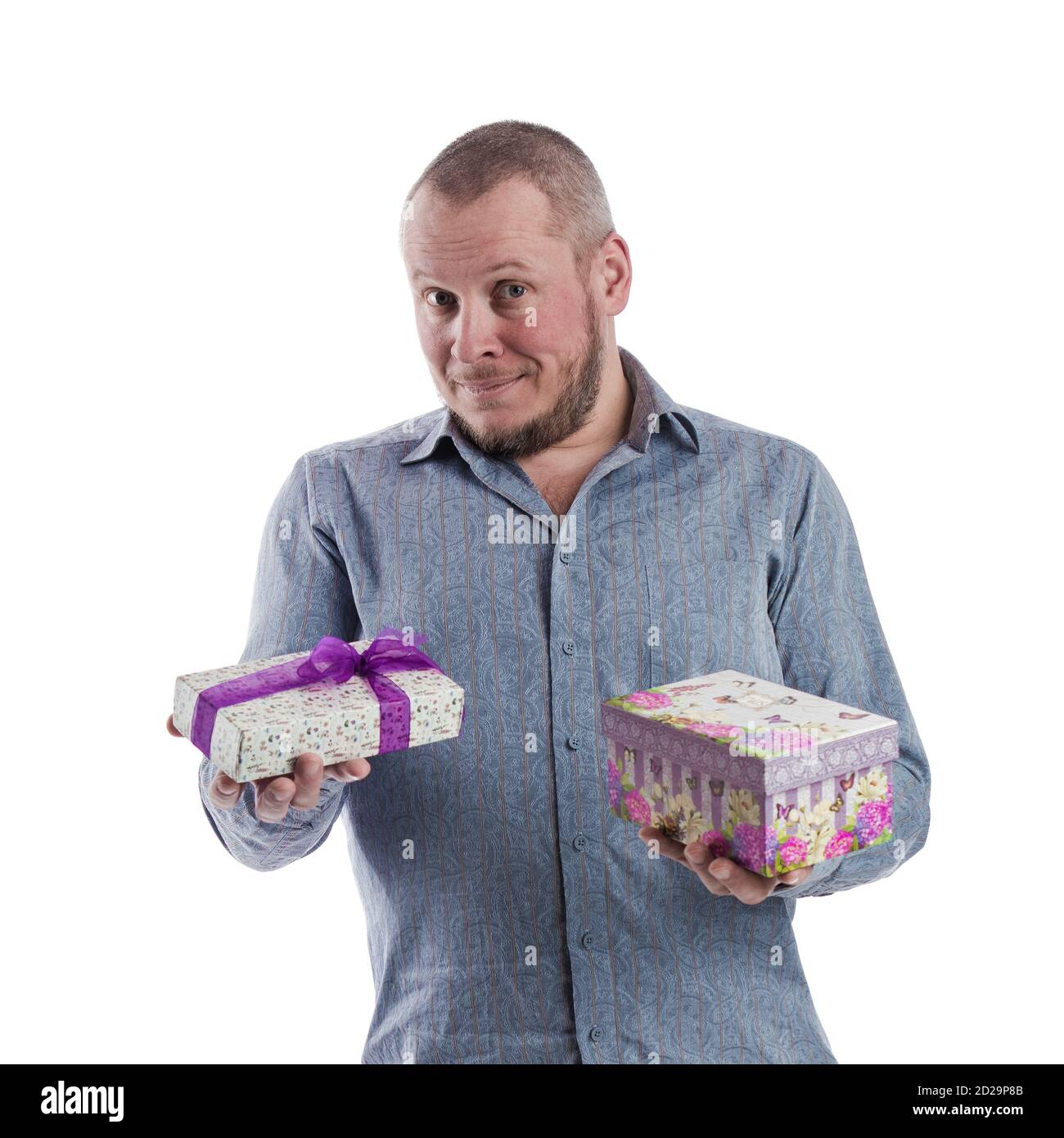 actor emocional hombre en una camisa gris con una caja con un regalo en las manos posando sobre un blanco fondo en el estudio Foto de stock