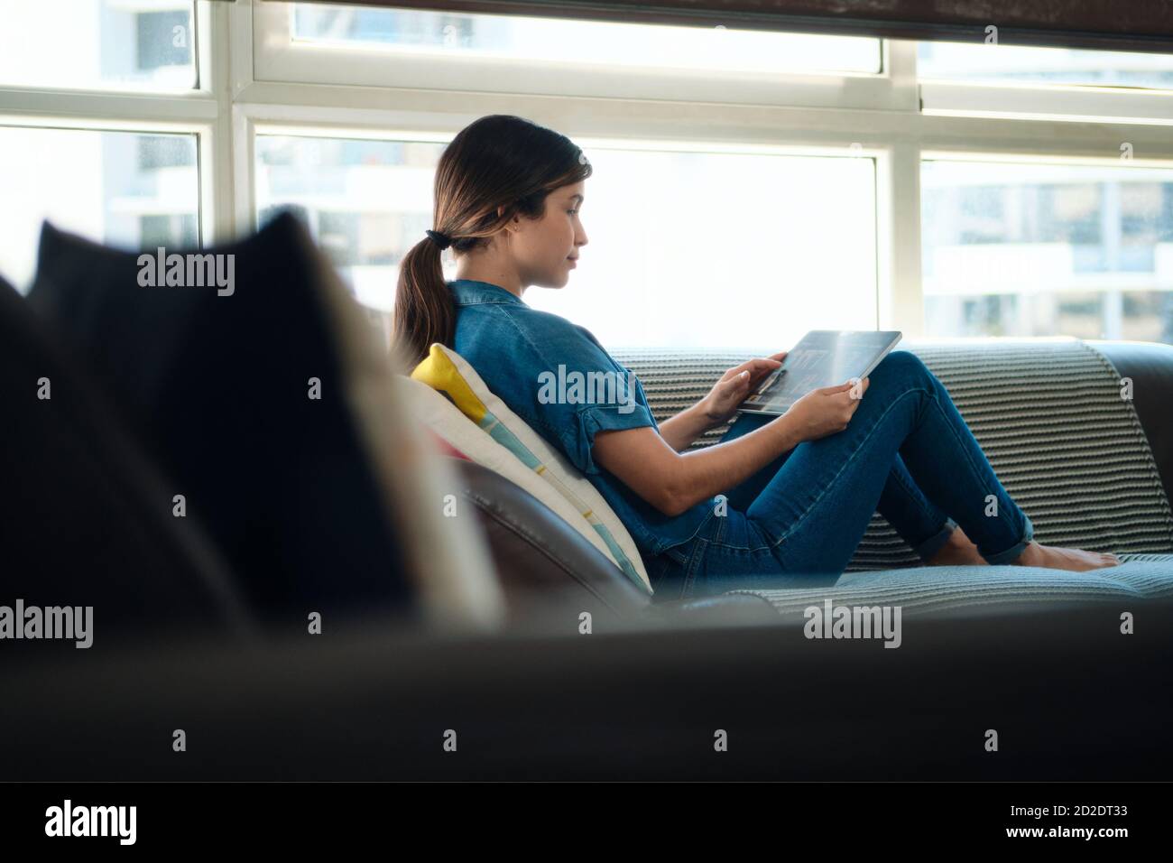 Mujer elegir película para streaming en Tablet PC Foto de stock