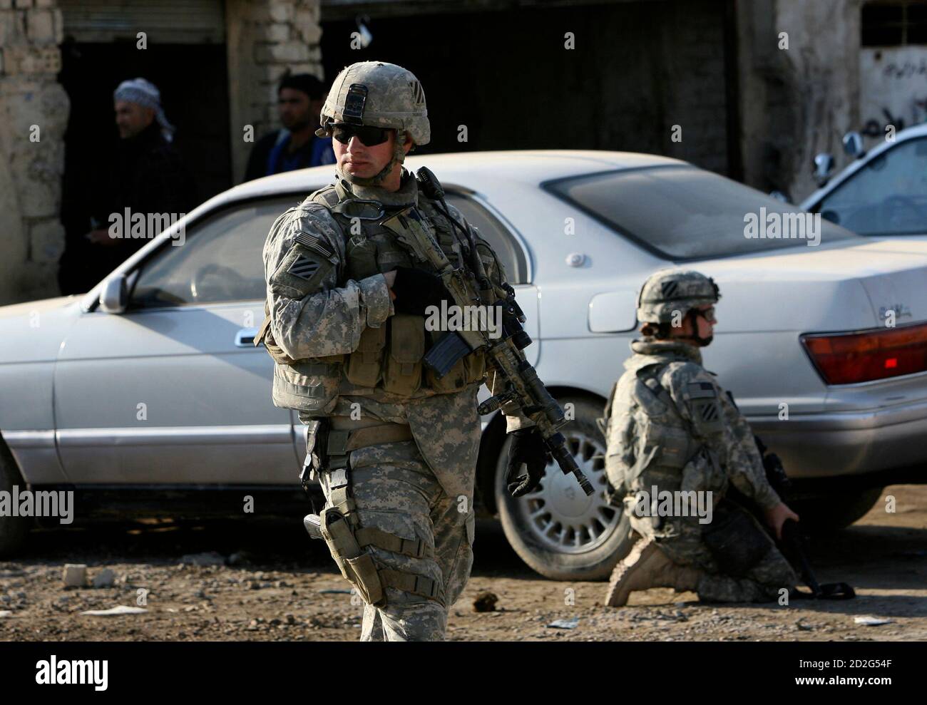 U.S. soldiers take up position near a vehicle during a joint patrol with Iraqi security forces in Jasr Diyala on the outskirts of southern Baghdad December 4, 2007. REUTERS/Erik de Castro (IRAQ) Foto de stock