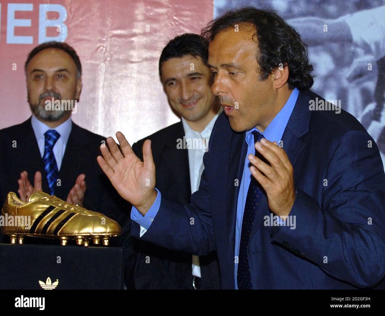 Michel Platini (R) hace gestos cerca de una "bota de oro" junto a la  leyenda del fútbol macedonio Darko Pancev (C) en Skopje el 4 de agosto de  2006. Platini entregó la