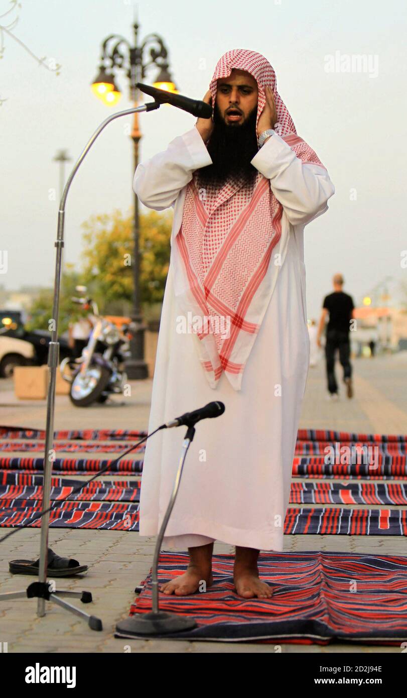 A member of the Committee for the Promotion of Virtue and Prevention of Vice, or religious police, calls for prayers on a street outside coffee shops in Riyadh June 27, 2010. The police have been ensuring that people watching World Cup soccer matches at the coffee shops continue to conduct their prayers during the duration of the soccer tournament. REUTERS/Fahad Shadeed (SAUDI ARABIA - Tags: SPORT SOCCER WORLD CUP RELIGION) Foto de stock