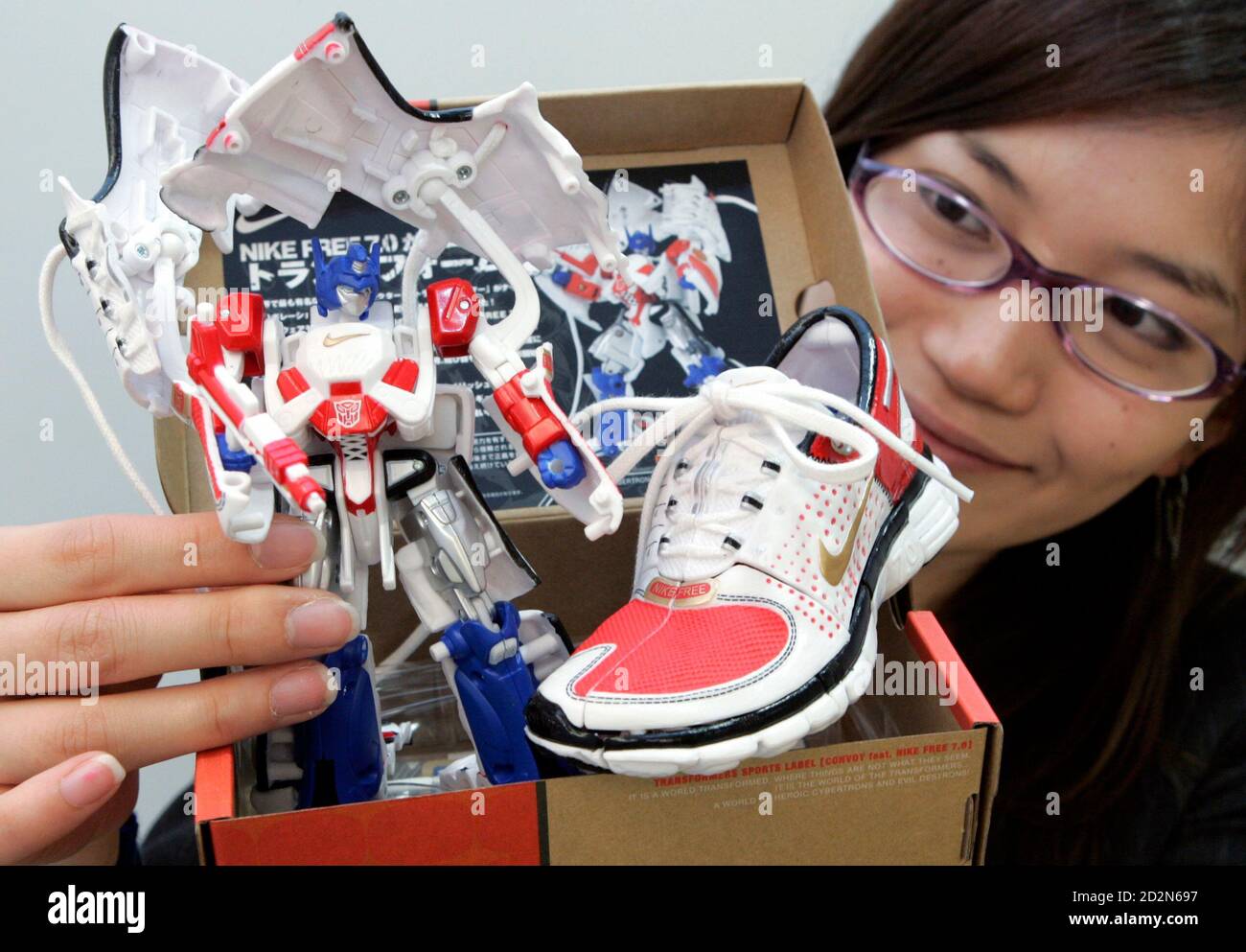 Chie Yamada, empleado de Tomy Company, hace una pose con la hazaña de  Transformers Sports Label Convoy. Nike Free 7.0' en Tokio 25 de abril de  2007. El juguete se transforma de