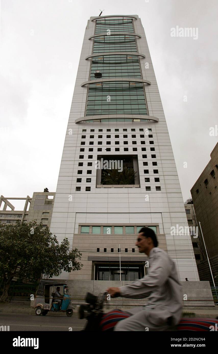 Commuters ride past the front of the MCB Bank tower in Karachi's business district on August 10, 2009. MCB, Pakistan's largest bank, will pay around $90 million to acquire the local operations of the Royal Bank of Scotland (RBS), a source with direct knowledge of the deal said on Monday. REUTERS/Akhtar Soomro (PAKISTAN BUSINESS) Foto de stock