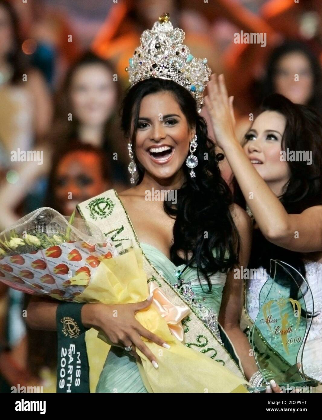 Miss Earth 2008 Karla Paula Henry helps Miss Brazil Larissa Ramos, 20, a  biology student, put on her crown after Ramos won the Miss Earth 2009, at  an eco-village in Boracay resort