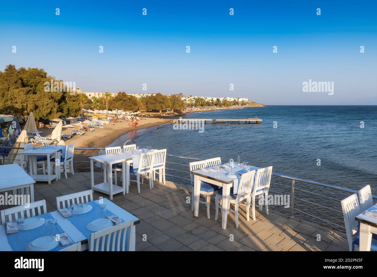 Restaurante con vistas al mar al atardecer en la playa de Akyarlar, Bodrum, Turquía. Foto de stock