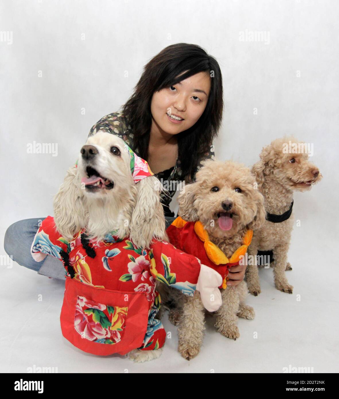 La diseñadora Hu Xi posará con sus perros de mascotas mientras llevan trajes  diseñados por ella en Beijing el 10 de junio de 2009. Hu, de 27 años,  comenzó a diseñar y