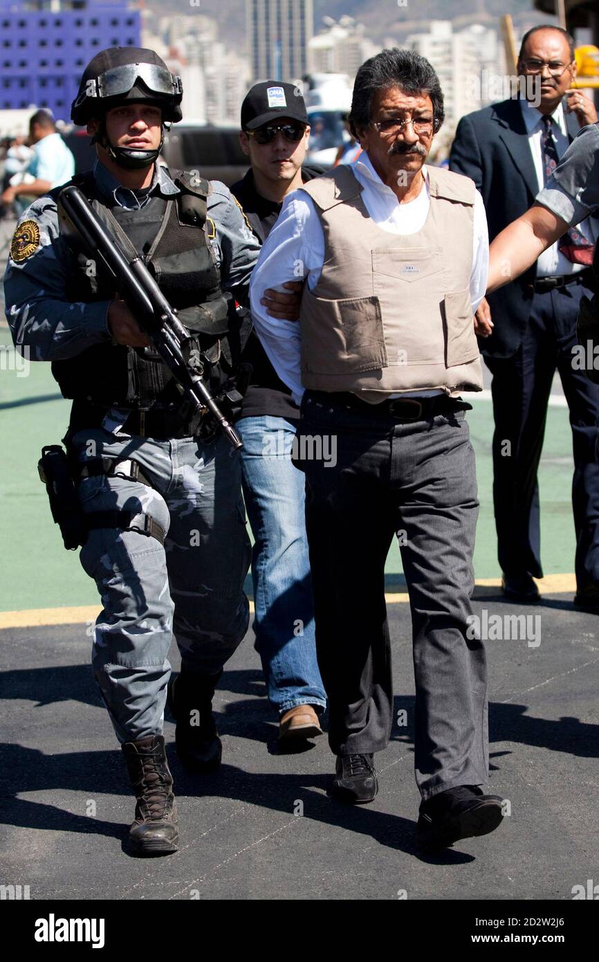 Suspected Colombian drug trafficker Salomon Camacho Mora (R) is escorted  during his extradition to the United States in Caracas February 2, 2010.  Venezuela on Tuesday deported to the United States alleged Colombian