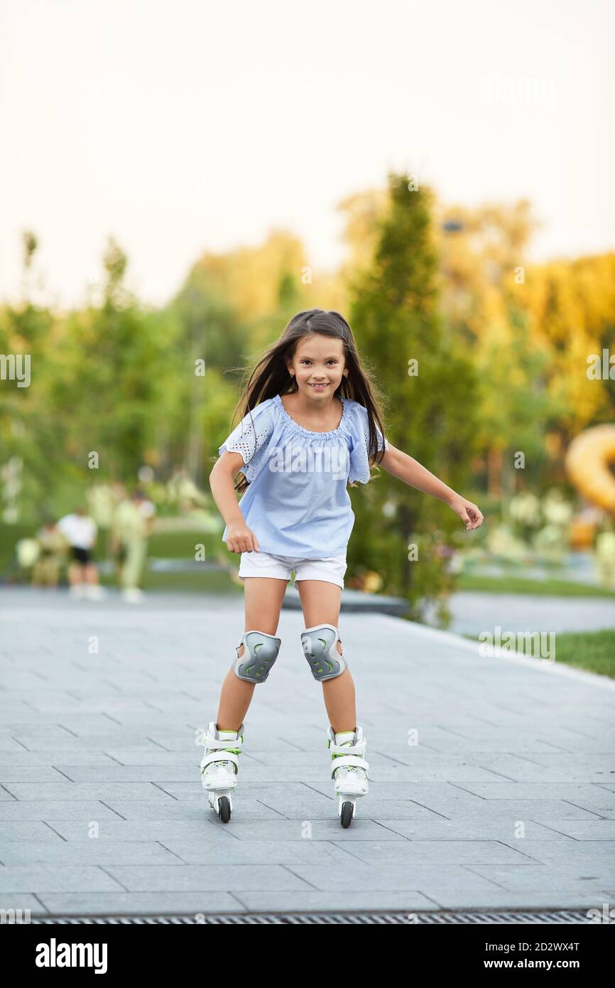sonriente niña patinando en el parque de verano Fotografía de stock - Alamy
