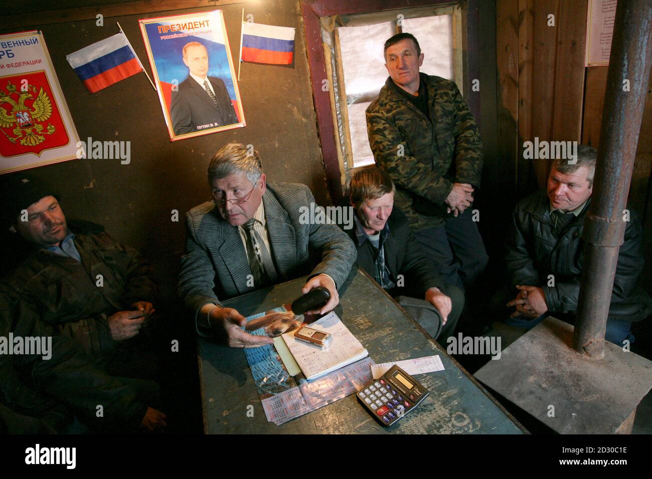 Los trabajadores se sientan en la oficina de su granja colectiva llamada así por el presidente ruso Vladimir Putin en la aldea de Gornovka el 16 de noviembre de 2007. La granja de Putin emplea a 25 técnicos que ganan un salario mensual de entre 4,000 y 5,000 rublos (entre 164 y 205 dólares), alrededor de un tercio del promedio nacional de 13,800 rublos. Foto tomada el 16 de noviembre de 2007. Para igualar la función RUSIA-VOTO/AGRICULTORES REUTERS/Andrei Kasprishin (RUSIA) Foto de stock