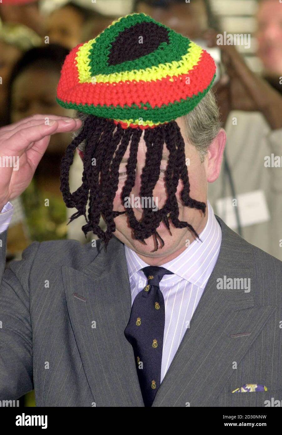 El Príncipe de Gales saluda a la comunidad local de Rasta mientras lleva un sombrero  Rasta durante una visita al centro comunitario de Trenchtown en Kingston,  Jamaica, durante su gira por el