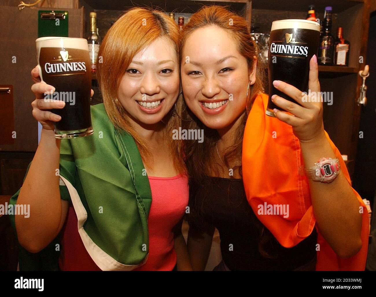 El personal japonés del bar Komomi Mise, 21, (izquierda) e Hiromi Imai, 20,  (derecha) en el Black Pig en Niigata, Japón, entrando en el humor irlandés  con Guinness, antes del juego del