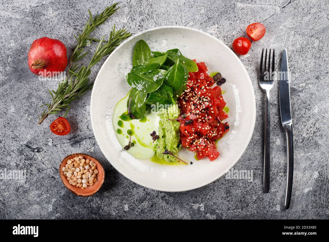 Exquisito pescado tartar filete de atún crudo con verdes de cerca en un plato blanco Foto de stock