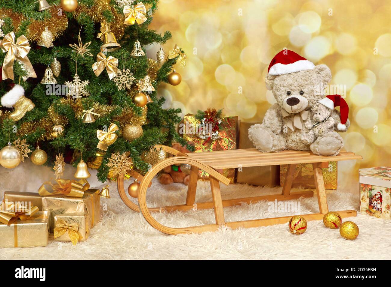 Árbol de Navidad con ornamentos de oro, osos de peluche, un trineo y  regalos. Disparo horizontal. Disparo de estudio Fotografía de stock - Alamy