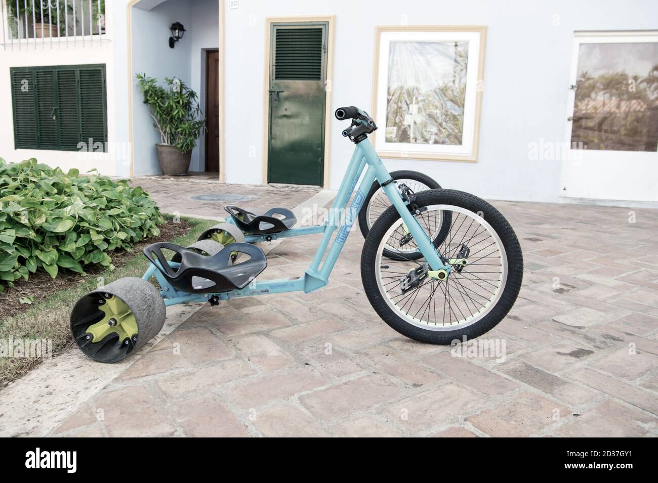 La romana, República Dominicana - 16 de febrero de 2016: Bicicleta  deportiva fresca o triciclo color azul con casco de hierro y plástico y  gran neumático de goma para la arena tiene