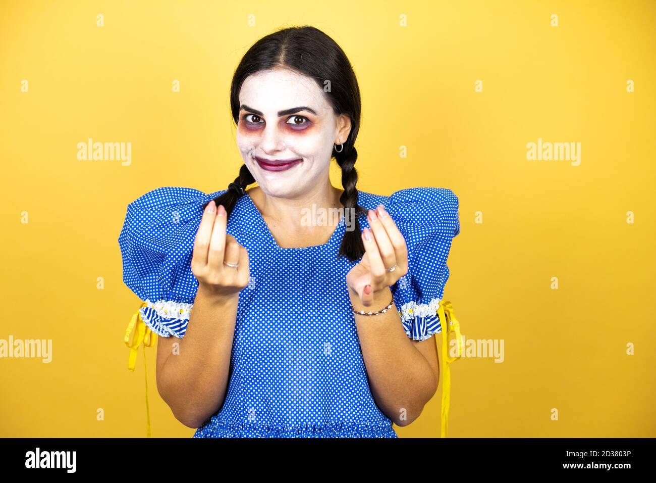 mujer que lleva una muñeca asustadiza disfraz de halloween sobre fondo  amarillo haciendo dinero gesto con las manos, pidiendo pago de sueldo,  millonario negocio Fotografía de stock - Alamy