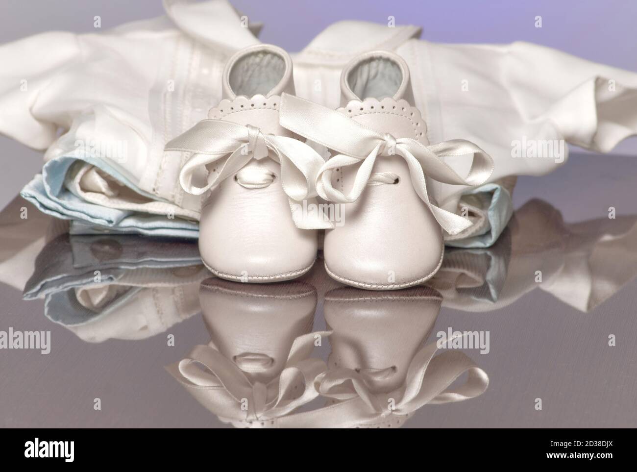 Zapatitos de bebé. zapatillas tejidas a mano para recién nacido niño o niña  en la pared gris.
