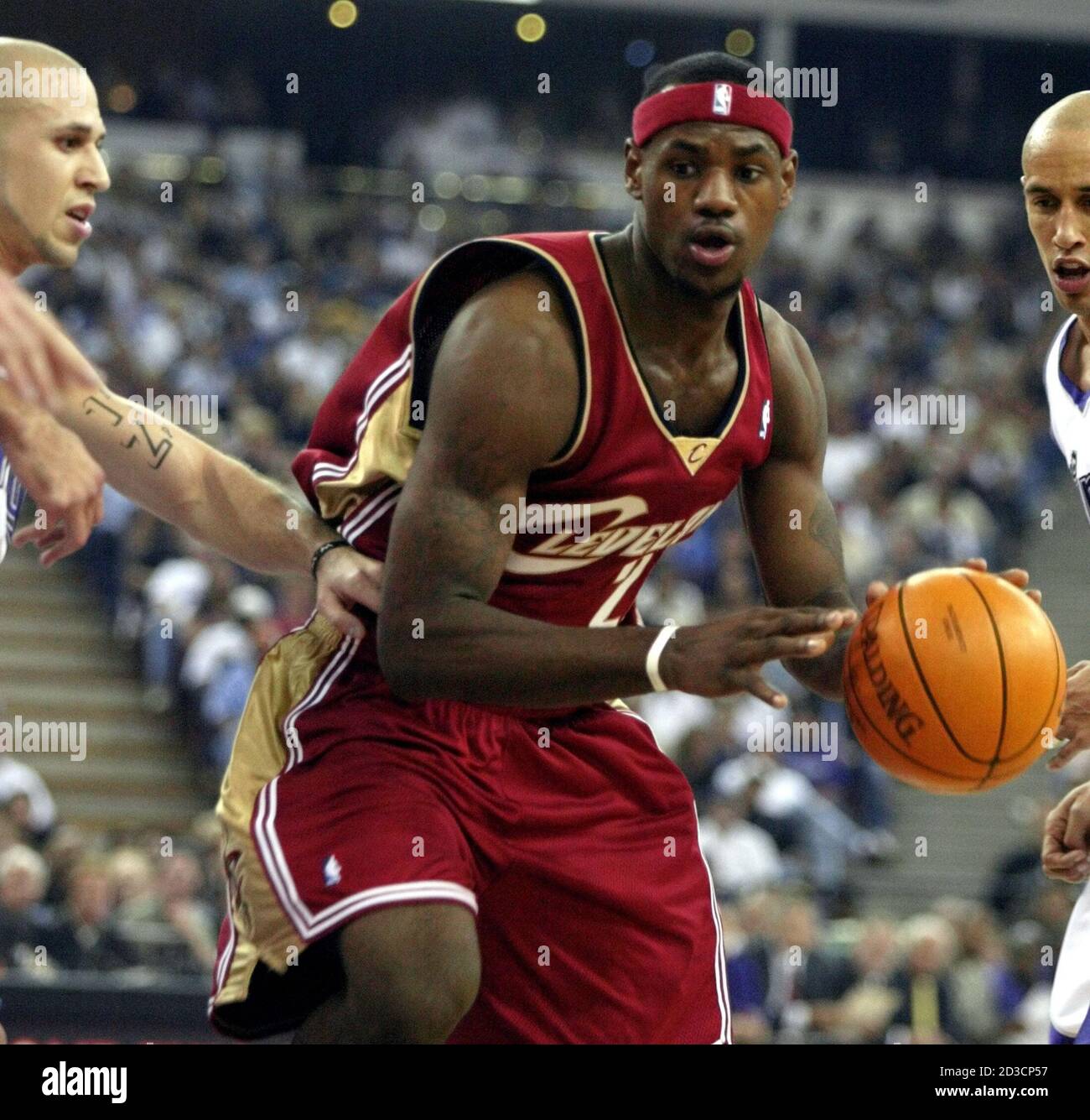 LeBron James de Cleveland Cavaliers (23) conduce al aro pasando por los  Reyes de Sacramento Mike Bibby (L) y Doug Christie (R) durante su debut en  la NBA contra los Reyes de