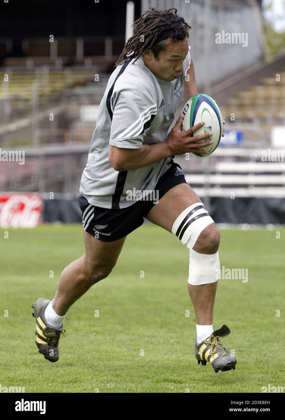 New Zealand All Blacks Tana Umaga corre sobre su rodilla lesionada a
