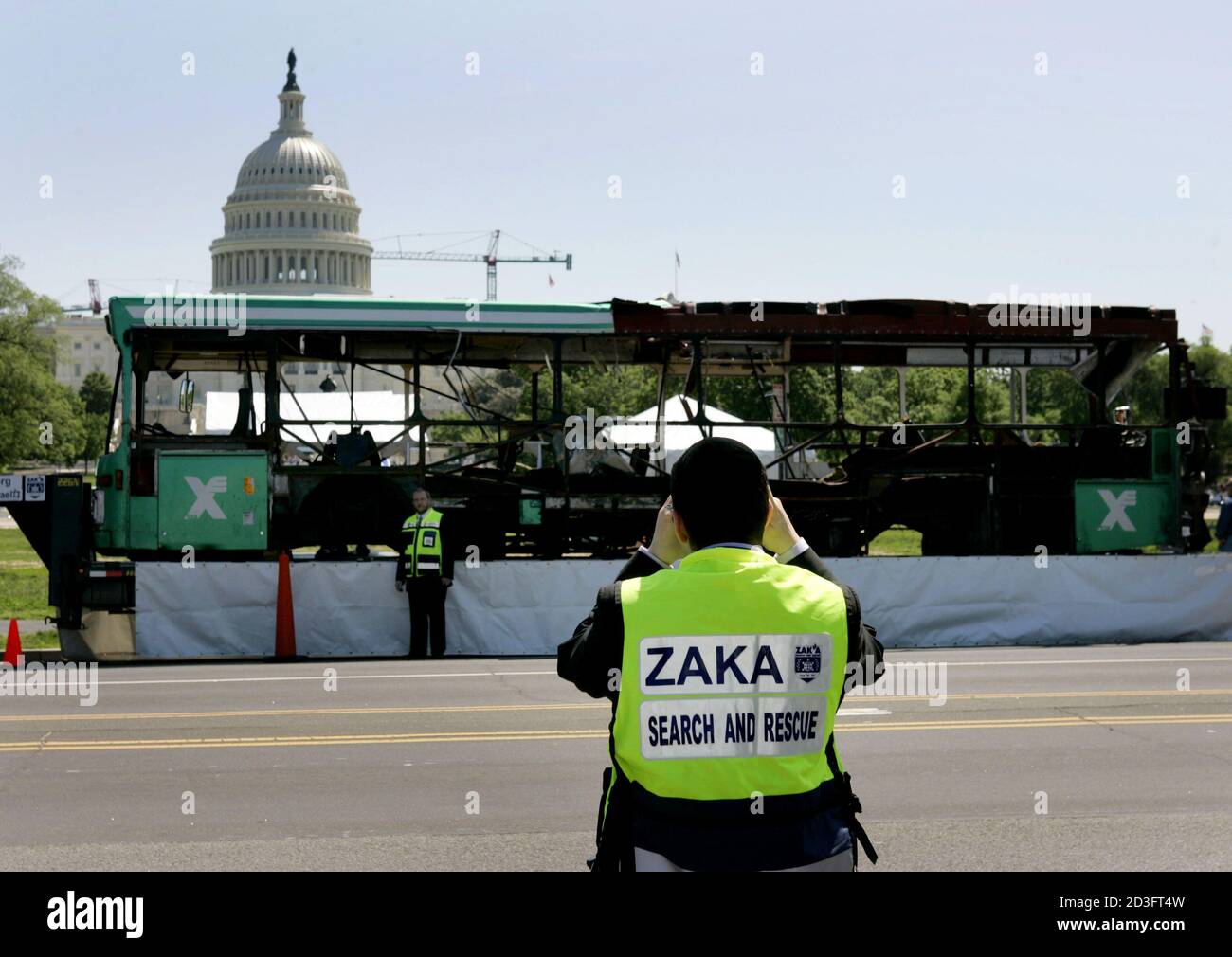 Matis Zahav (L), Director Ejecutivo de los voluntarios de rescate y recuperación de Zaka que trabajan en Israel, tiene su foto tomada por un colega frente a un autobús israelí destruido que se exhibe fuera del edificio del Capitolio de los Estados Unidos en Washington el 6 de mayo de 2004. Las organizaciones "Cristianos para Israel" y Zaka llevaron el autobús número 19 a los Estados Unidos, Que fue golpeado por un terrorista suicida, matando a 11 personas e hiriendo a más de 50 en Jerusalén el 29 de enero, para demostrar que los ataques terroristas pueden atacar en cualquier lugar y que todas las religiones deben unirse en una causa común contra los ataques terroristas. REUTERS/Jason Reed JIR/J Foto de stock