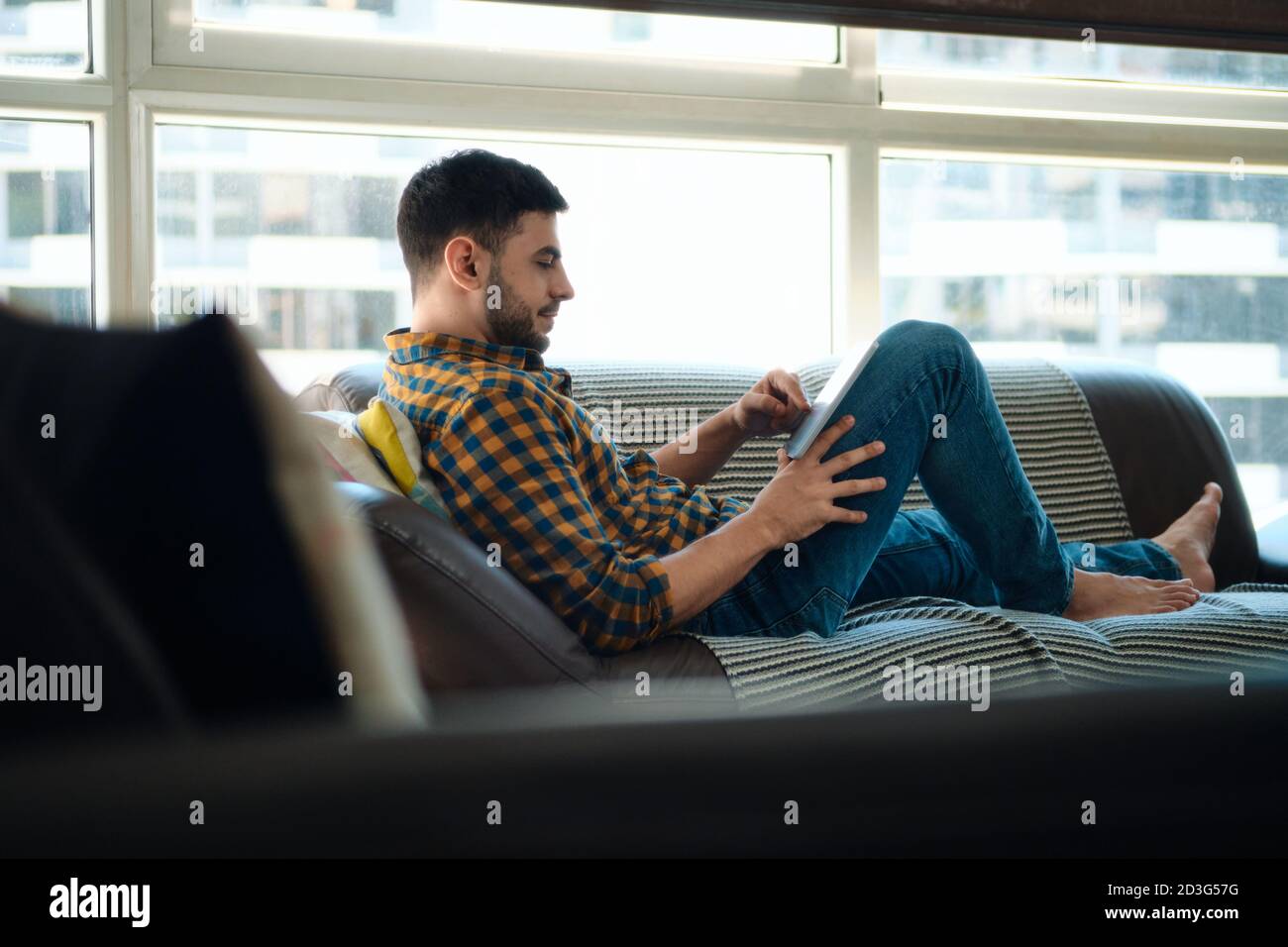 Hombre eligiendo película para streaming en Tablet PC Foto de stock