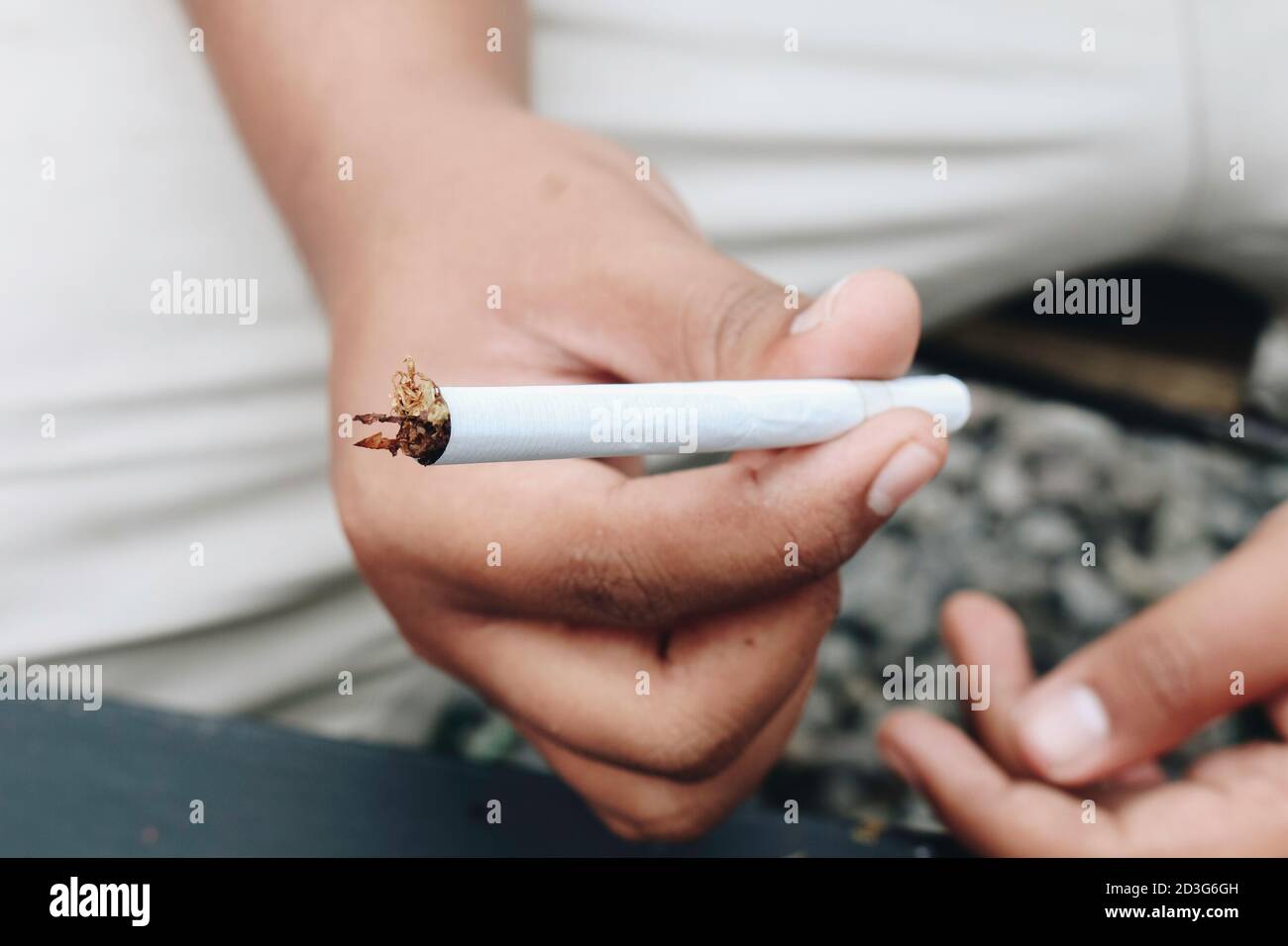 Man Hand hace un cigarrillo con herramientas tradicionales rodantes, Hands closeup. Foto de stock