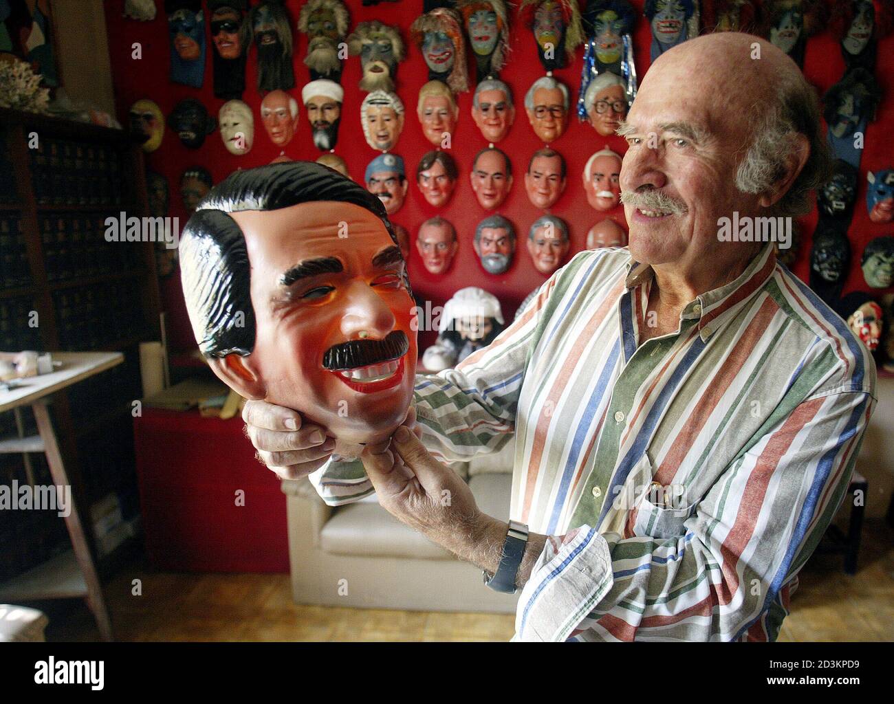 El artesano español Armando Valles sostiene una máscara del presidente  español José María Aznar en su fábrica de vestuario en un suburbio de Río  de Janeiro, el 26 de junio de 2003.