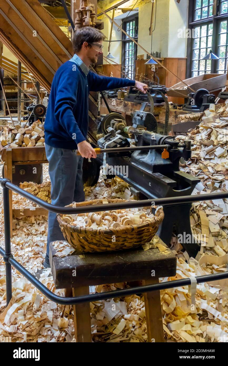 Un hombre demostrando un torno de madera en el Stott Parque Bobbin Mill para la fabricación de bobinas de madera para el industria textil Foto de stock